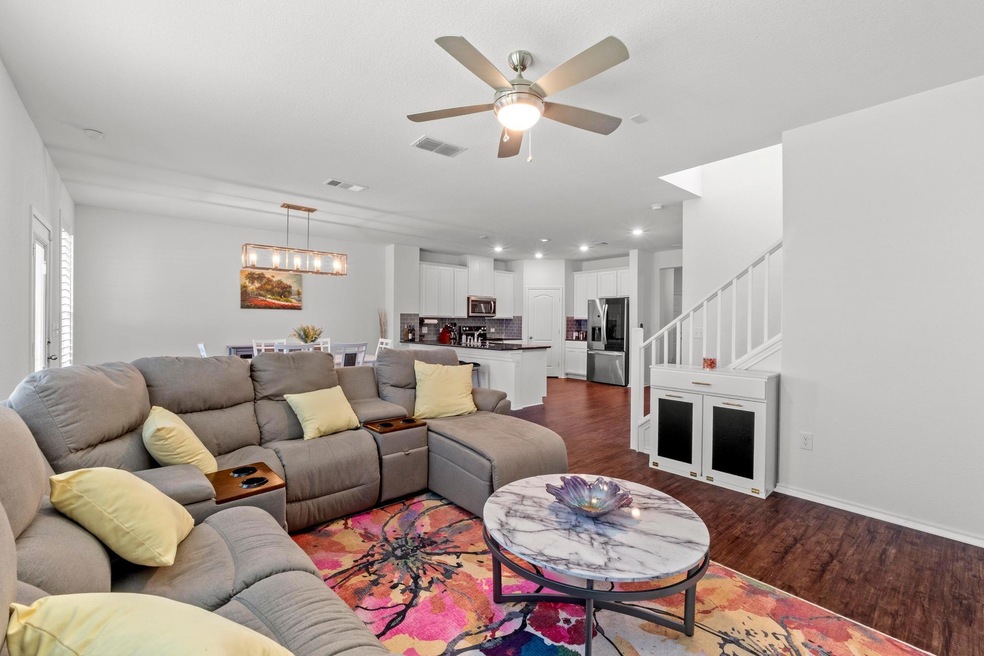Living room with stairway, dark wood-style floori