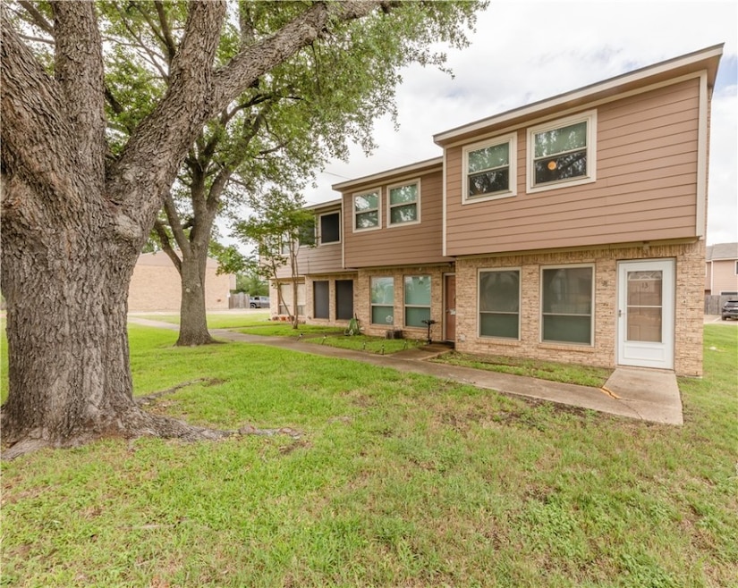 View of front of home with a front lawn and brick