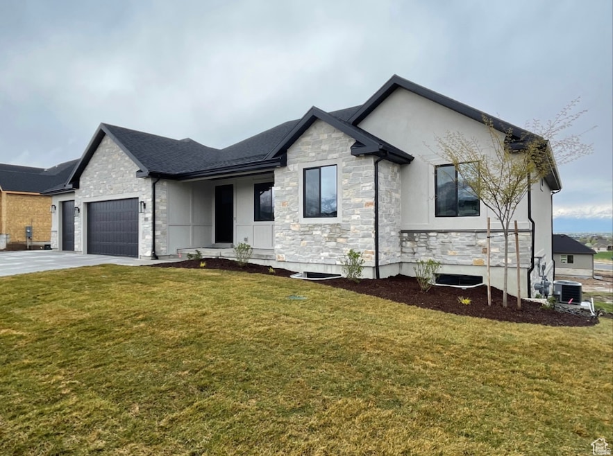 View of front of home with stone siding, a front lawn, driveway, an attached garage, and covered porch
