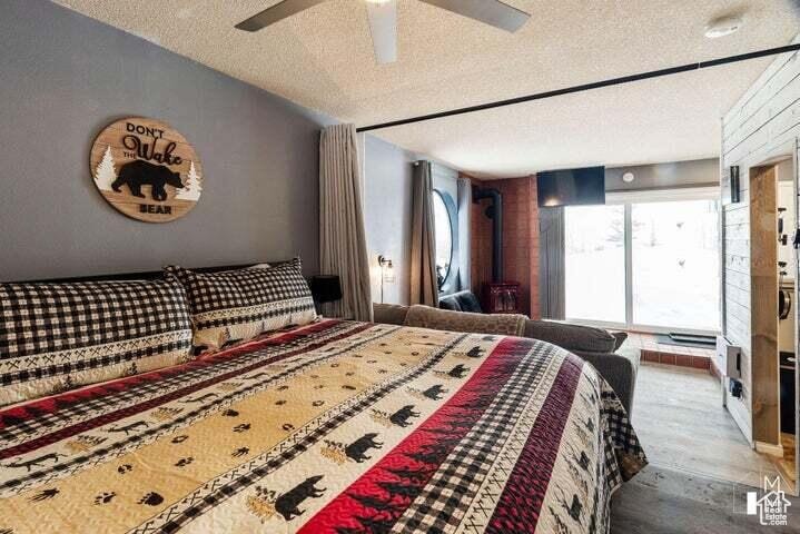 Bedroom featuring a textured ceiling, wood finished floors, and ceiling fan