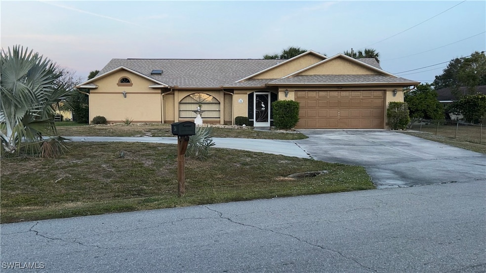 Ranch-style house featuring a front yard and a gar