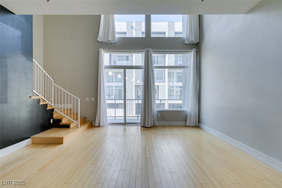 Unfurnished living room with stairway, baseboards,