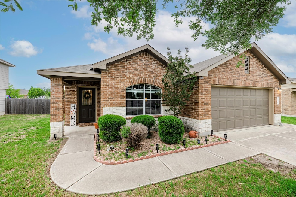 Ranch-style home featuring brick siding, driveway, a garage, stone siding, and a shingled roof