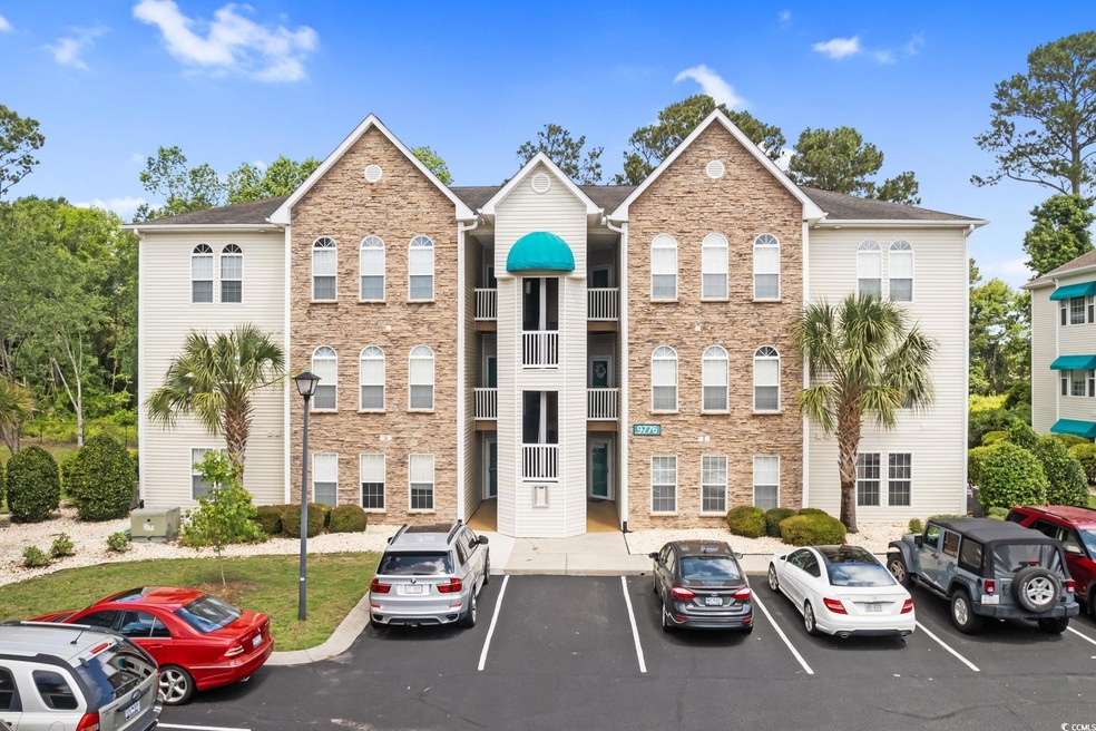 View of building exterior with uncovered parking