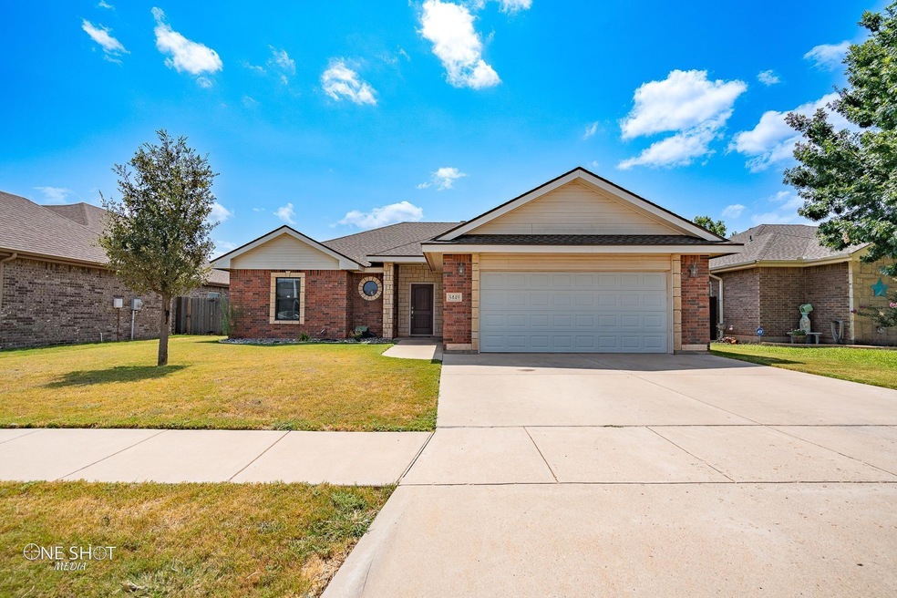 Ranch-style house featuring a garage and a front y