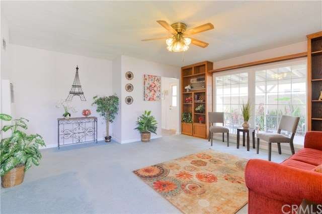 You are greeted with all this natural light, bright and open floor plan! Built in custom book shelves and the nice lighted ceiling fan. That picture window is to die for and shows the serene patio area with greenery.