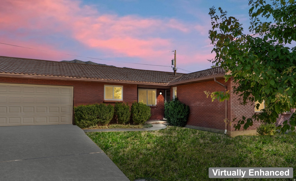 Single story home with brick siding, a lawn, driveway, and a tile roof