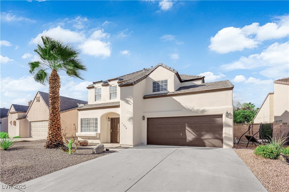 Traditional home featuring stucco siding, driveway, a tiled roof, and a garage