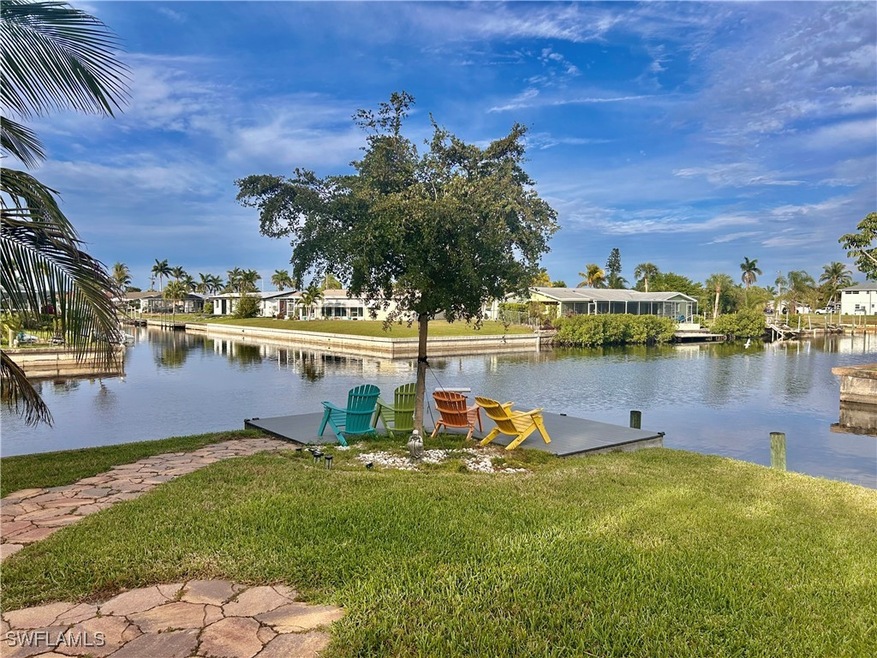 Dock area with a yard, a water view, and a residen