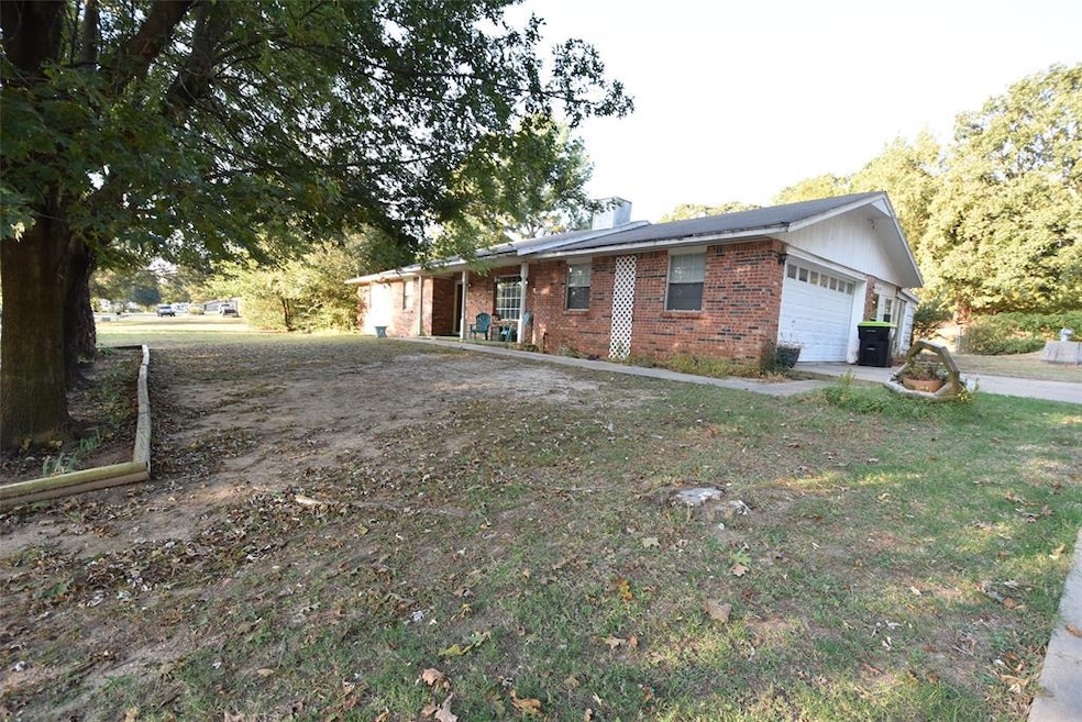 View of front of house featuring brick siding, a chimney, and an attached garage