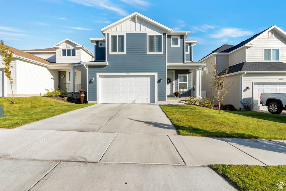 View of front of home featuring board and batten siding, a front lawn, an attached garage, and driveway