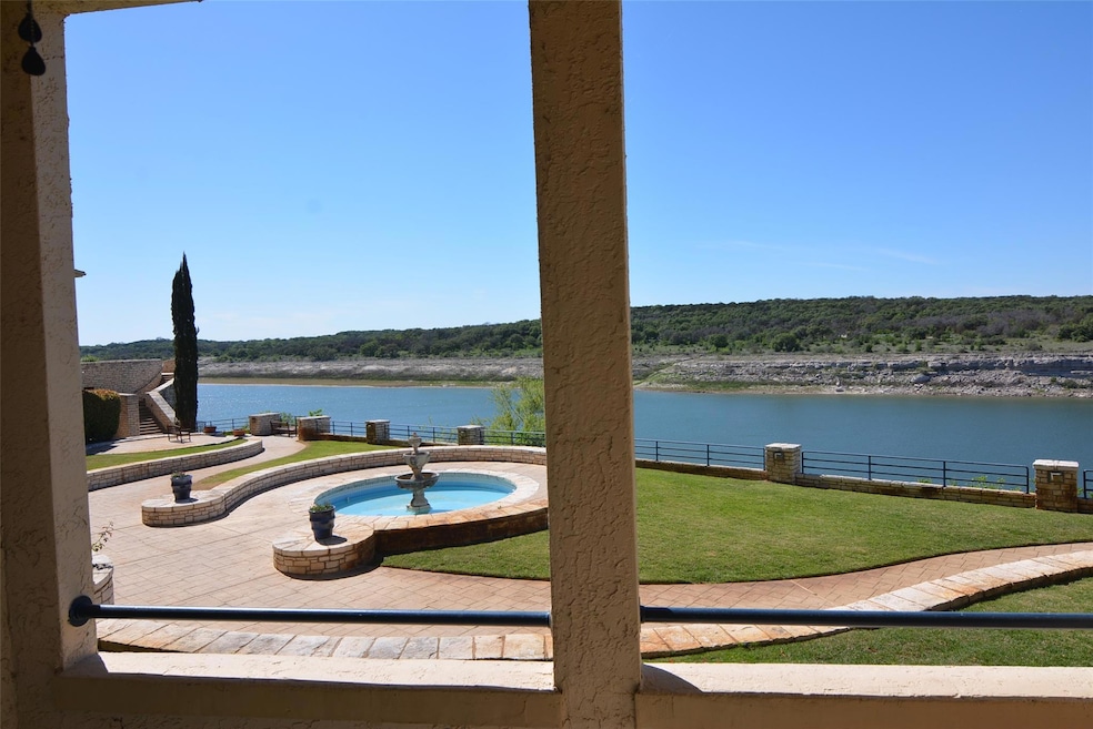 View of patio with a water view and fence