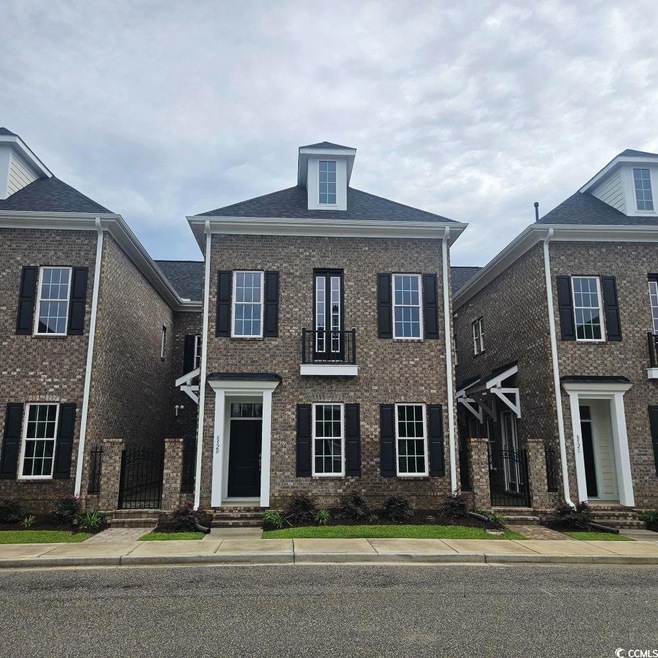 Colonial inspired home with brick siding