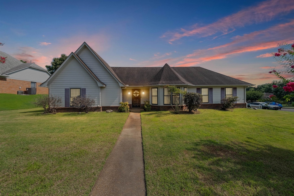 View of front of home featuring a yard and a shingled roof
