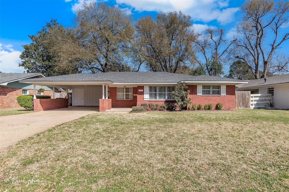 Ranch-style home with an attached carport, fence, 