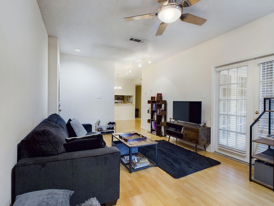 Living room with ceiling fan, wood finished floor