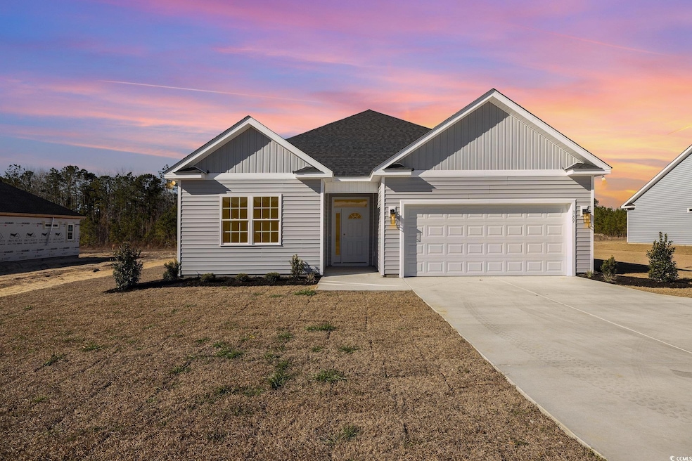 View of front of property with a yard and a garage