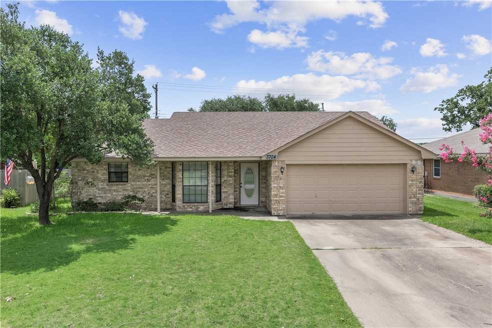 Single story home with brick siding, concrete driv