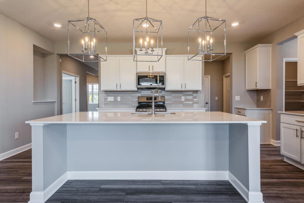 This kitchen has the WOW factor!! Gorgeous pendants, huge waterfall island and ample countertop space. What's not to love?