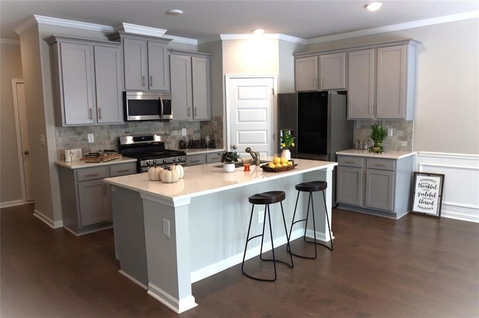 Kitchen featuring appliances with stainless steel finishes, gray cabinetry, ornamental molding, and recessed lighting