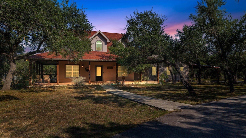 View of front facade with covered porch, stucco siding, and a front lawn