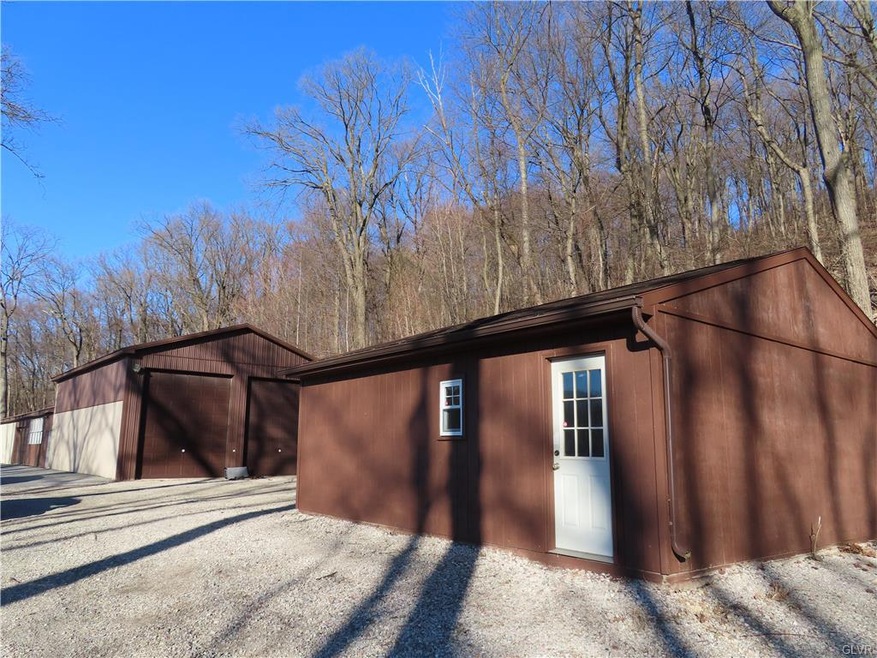 Photo shows large vehicle garage/shop and 2 car de
