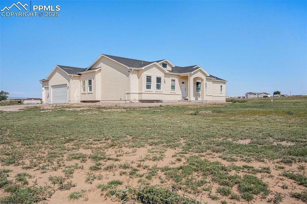 Ranch-style home with a front lawn, an attached garage, and stucco siding