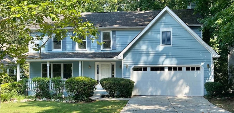 View of front of house featuring a porch and a gar