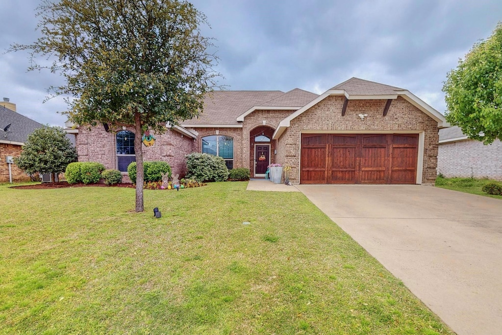 View of front of house with a garage and a front y