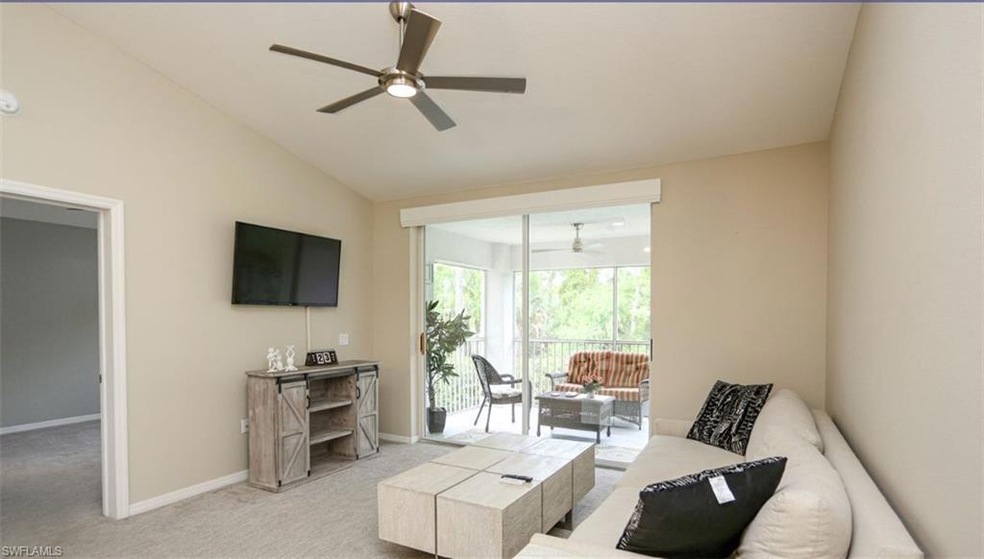 Carpeted living room featuring ceiling fan and lof