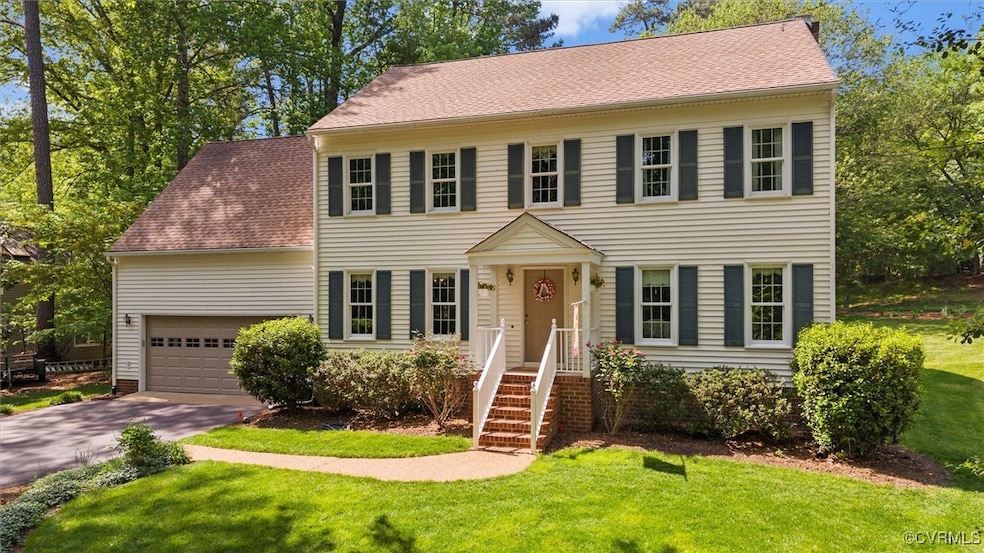 Colonial house with roof with shingles, a front ya