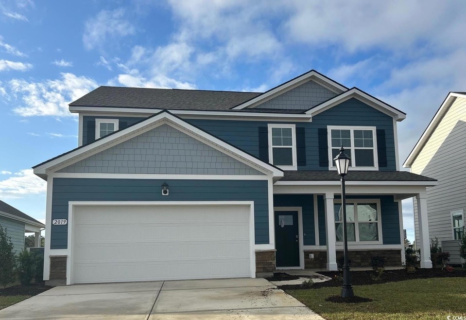 Craftsman-style home featuring a front lawn, drive