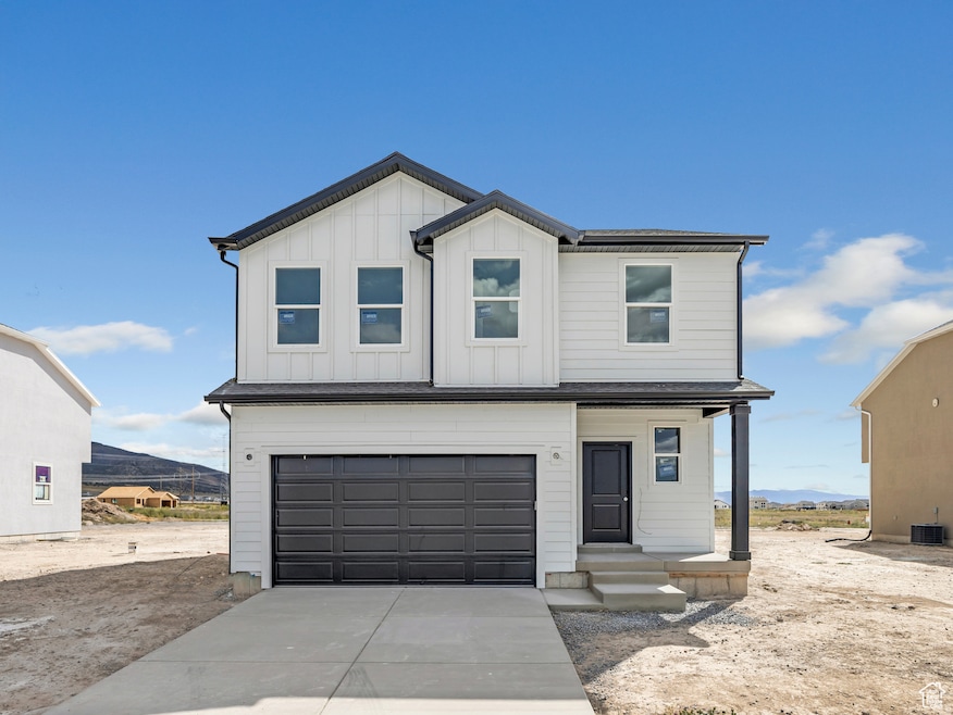 Modern farmhouse with a garage, a mountain view, concrete driveway, and board and batten siding