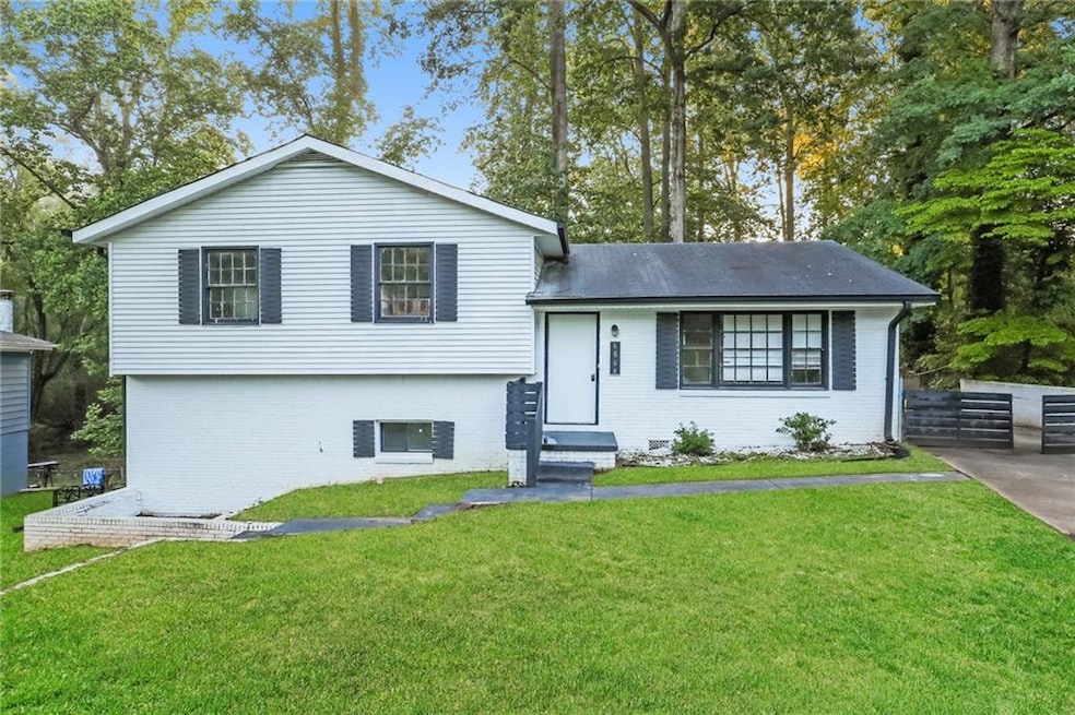 Tri-level home with a front yard and brick siding