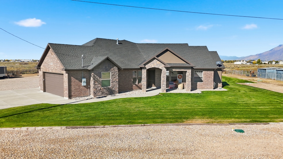 View of front of house featuring a front yard, driveway, brick siding, stone siding, and a shingled roof