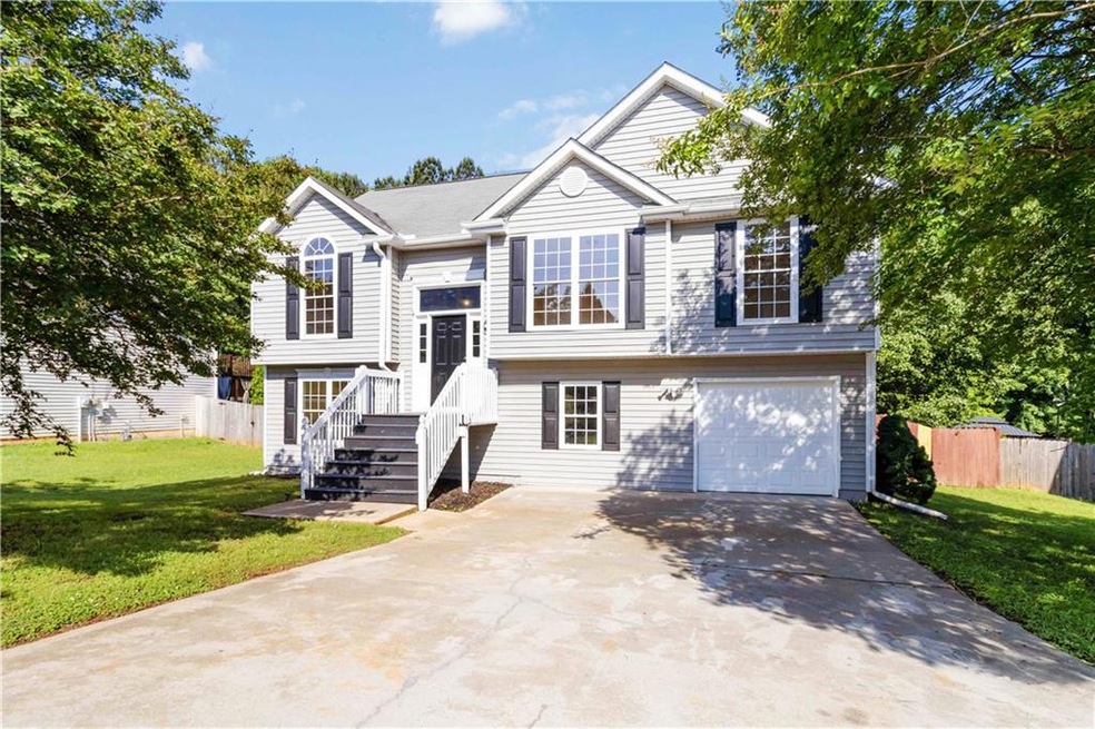 Raised ranch featuring a garage and driveway