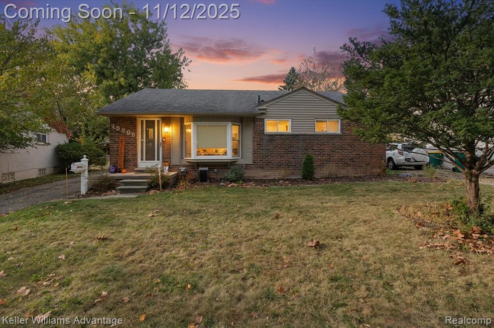 View of front of home featuring brick siding, a front yard, and covered porch