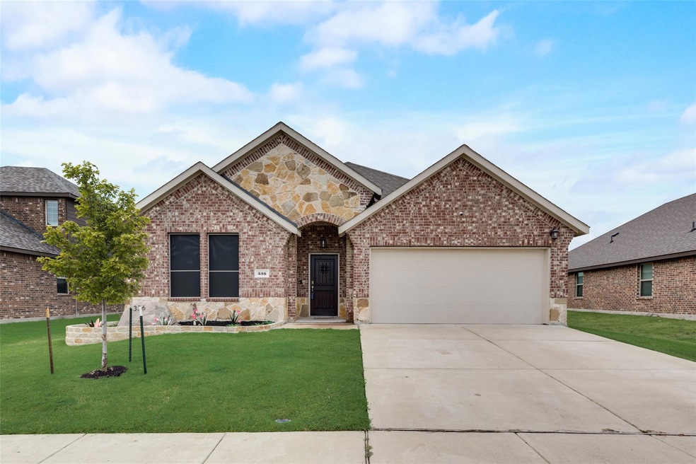 View of front of house with a garage and a front lawn