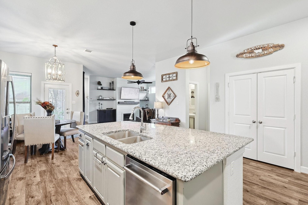 Kitchen with light stone counters, pendant lightin