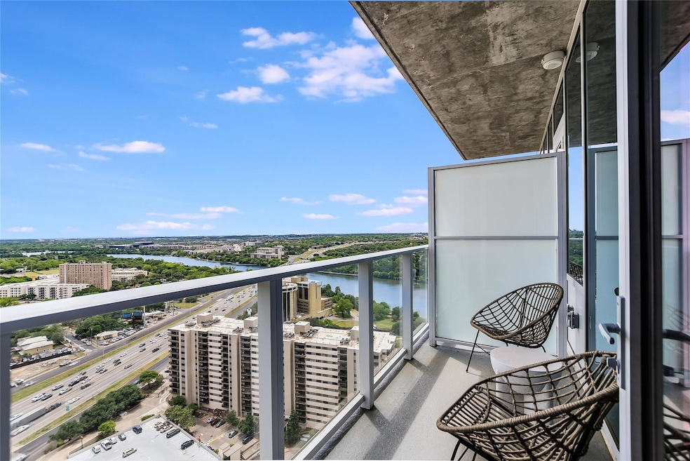 Balcony featuring a water view and a city view