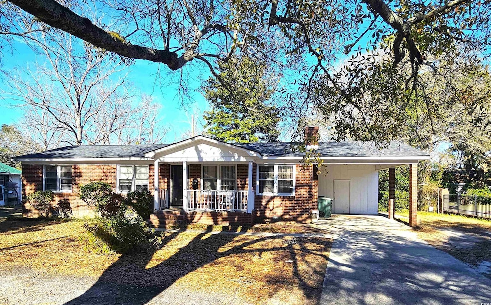 Ranch-style home with brick siding, covered porch, concrete driveway, and an attached carport