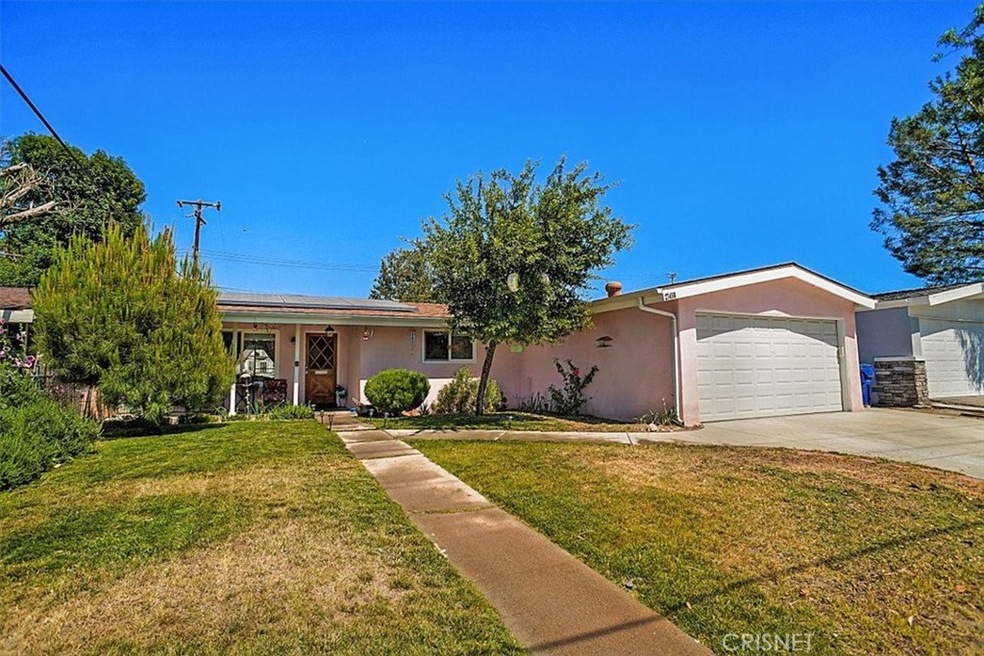 Front of home with cement driveway and 2-car attached garage with direct access.
