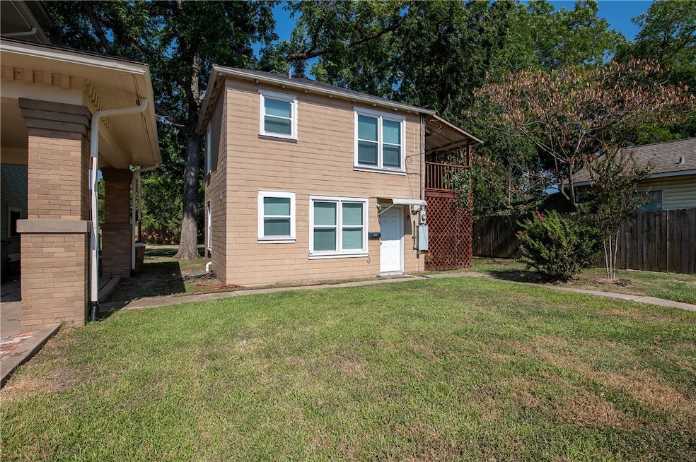 Back of property with fence, a lawn, and a balcony