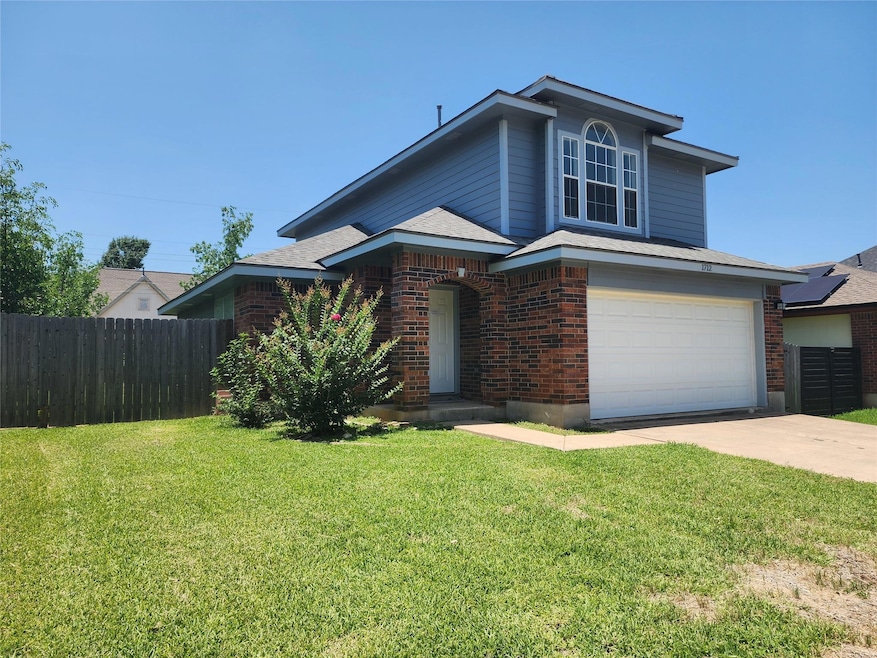 View of front of house with a garage, brick sidin