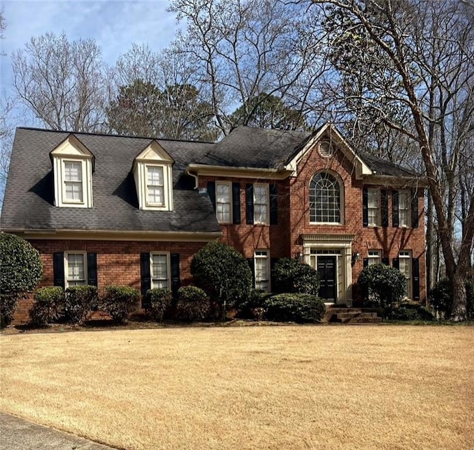 View of front of home with brick siding, a front y