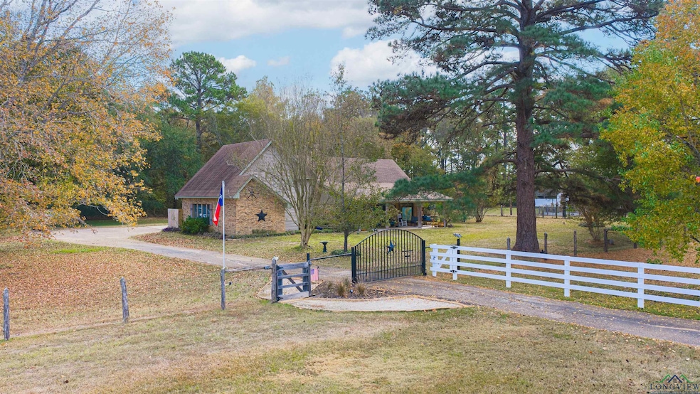 View of front of property with a gate, a fenced front yard, stone siding, and driveway