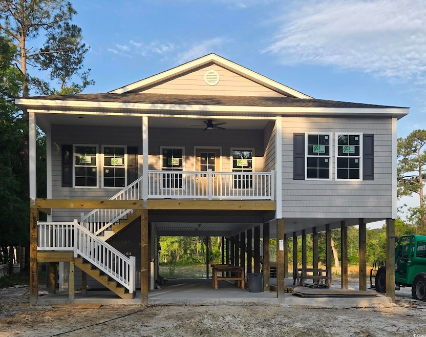 Beach home featuring stairway, ceiling fan, and a carport