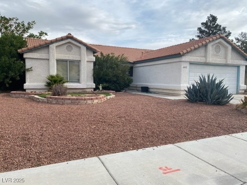 View of front of house with stucco siding, a garag