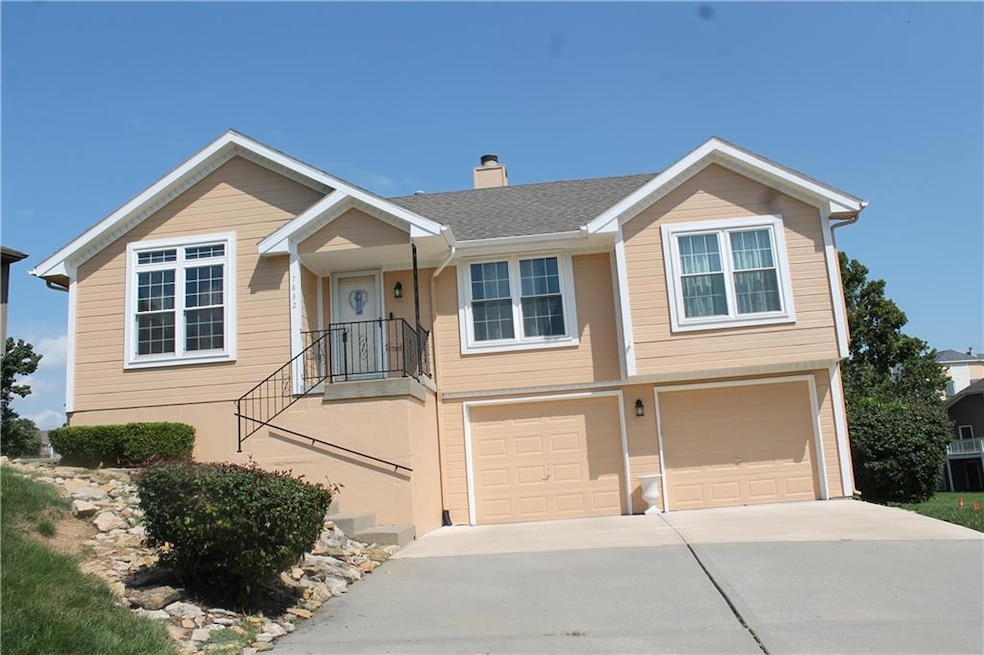 View of front of home with a garage, concrete driveway, and a chimney