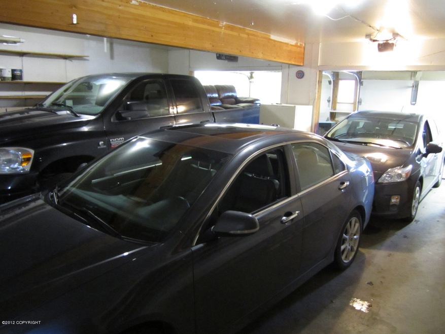 Garage shown with 2 cars and a truck